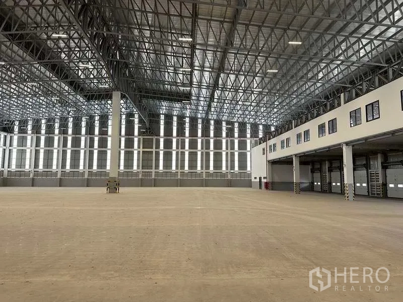Factory for rent or sale in Samut Prakan - Wide warehouse space with high-bay ceiling and continuous loading bays.