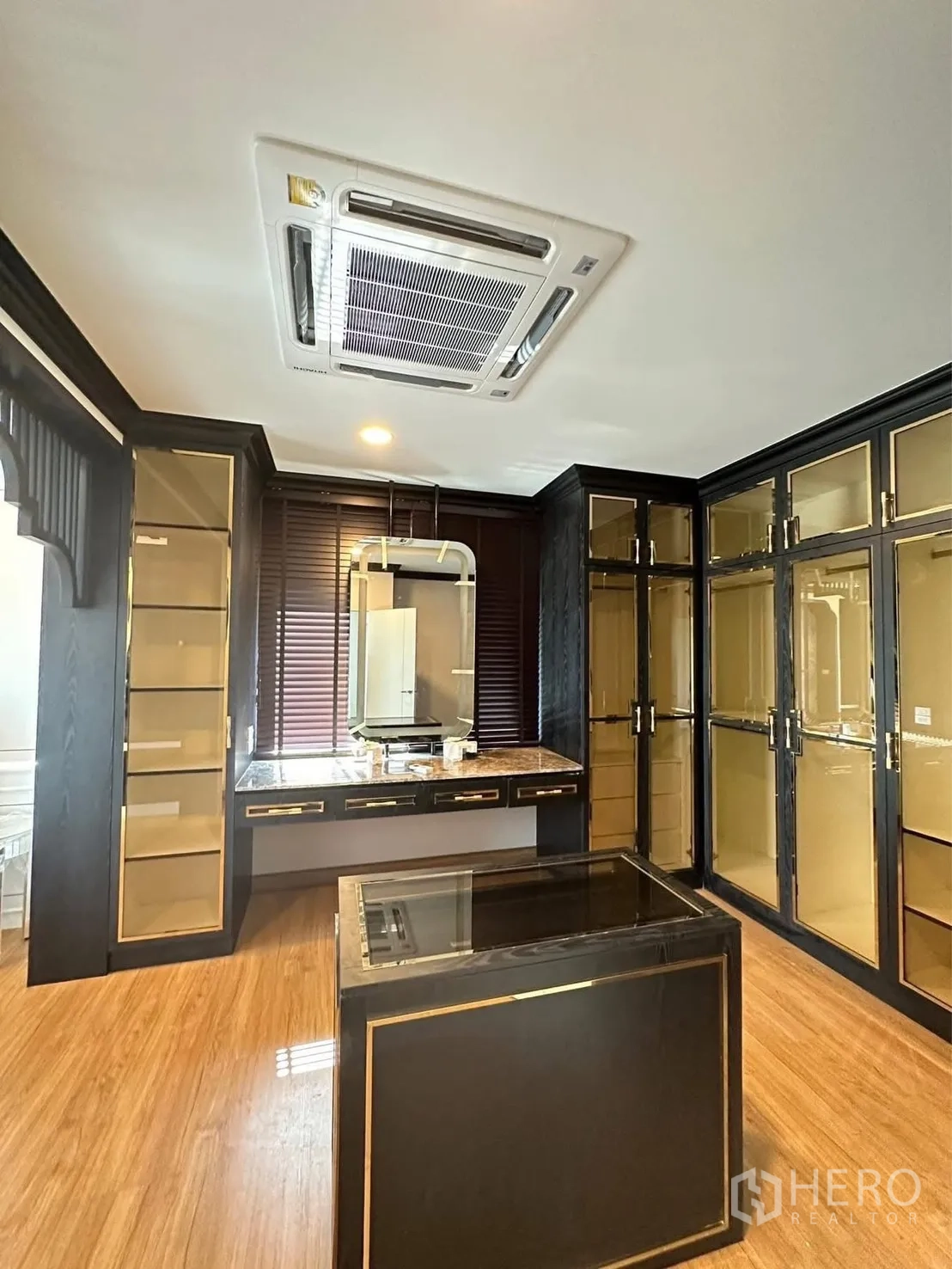 Detached House for rent in Bang Phli, Samut Prakan - Spacious walk‑in closet with glass-front wardrobes, vanity, island, and cassette air conditioner.