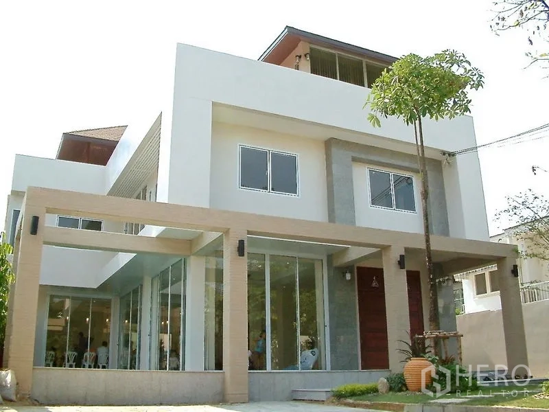 Detached House for rent in Watthana, Bangkok - Front facade of a contemporary detached home with wide glass doors and clean lines.