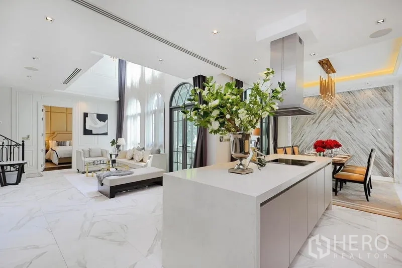 Detached House for rent or sale in Watthana, Bangkok - Sleek white island kitchen adjoining airy living and dining zones.
