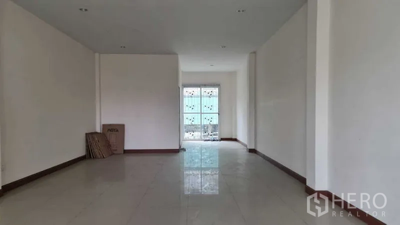 Townhouse for  in Lam Luk Ka, Pathum Thani - Empty elongated living space viewed toward the front entrance.
