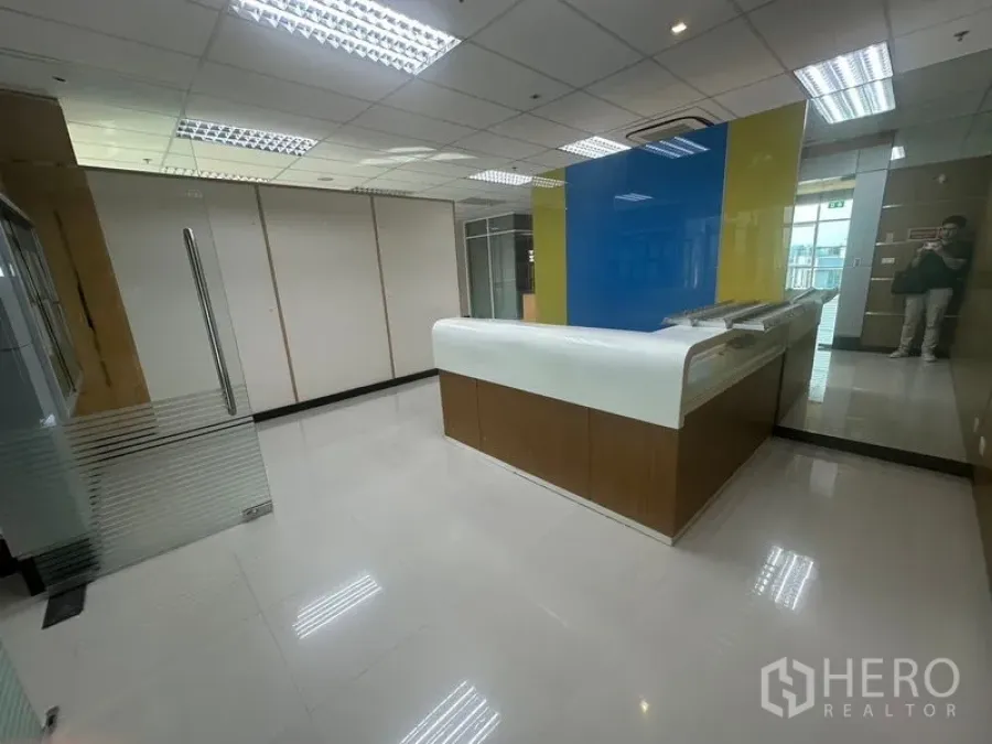 Office Space for rent in Suan Luang, Bangkok - Modern reception lobby with curved counter, glass door and glossy tiled flooring.