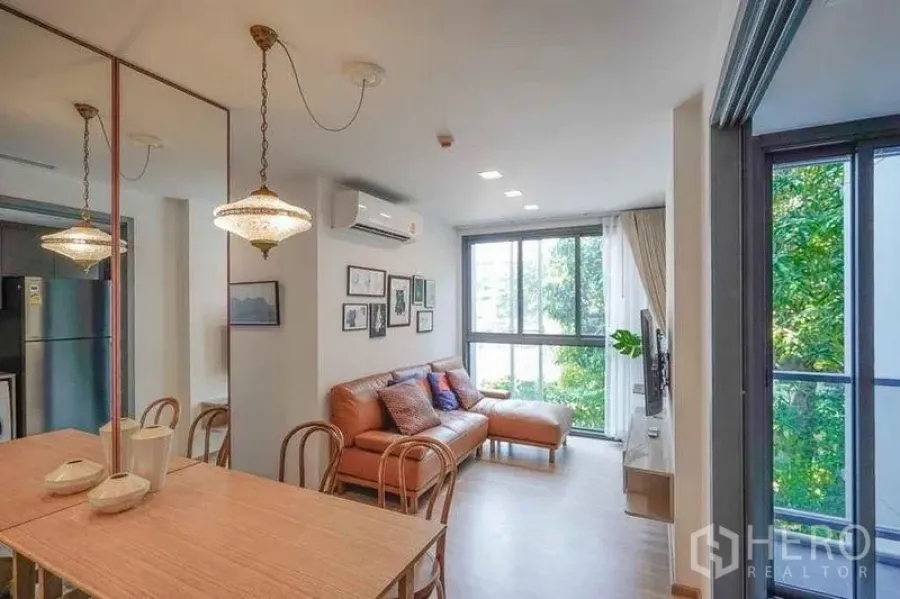 Condominium for rent in Watthana, Bangkok - Overview of dining and living zone with greenery outlook from wide windows.