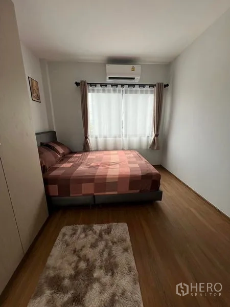 Townhouse for rent - Secondary bedroom with window, air conditioning and warm wood flooring.