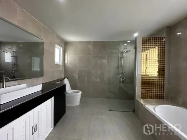 Detached House for sale in Lam Luk Ka, Pathum Thani - Spacious bathroom featuring a glass shower, bathtub and long countertop.