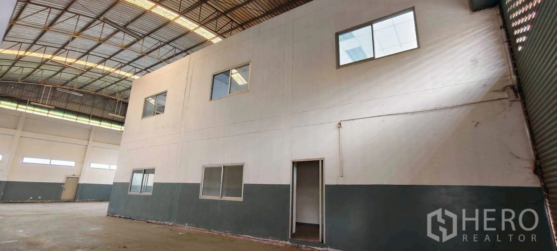 Factory for rent in Khlong Luang, Pathum Thani - Spacious warehouse interior with high steel-truss roof and internal two-storey office.