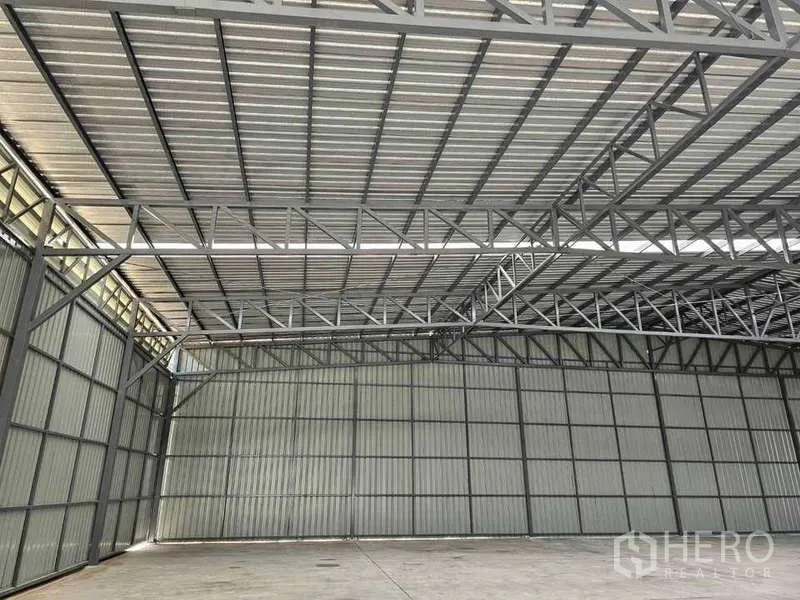Warehouse for rent in Pak Kret, Nonthaburi - Close-up of steel roof framing and insulated metal panels in the warehouse.
