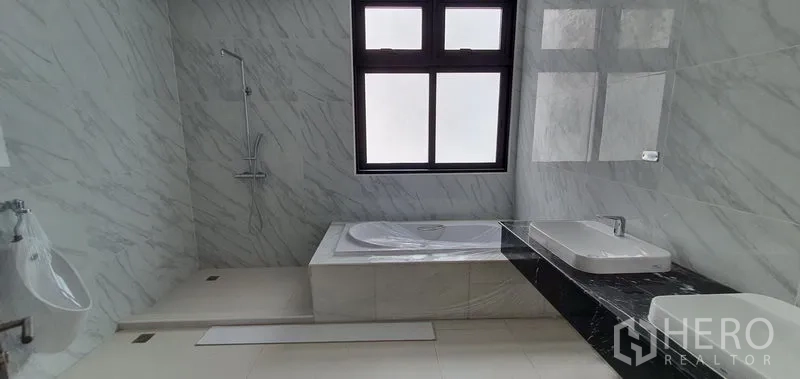 Home Office for rent or sale in Watthana, Bangkok - Large marble bathroom with bathtub, separate shower, and frosted window.