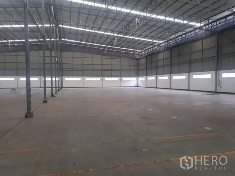 Warehouse for rent in Si Racha, Chon Buri - Open warehouse floor with clerestory windows and metal truss roof for natural illumination.