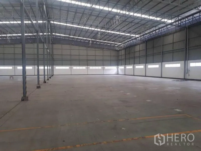Warehouse for rent in Si Racha, Chon Buri - Open warehouse floor with clerestory windows and metal truss roof for natural illumination.