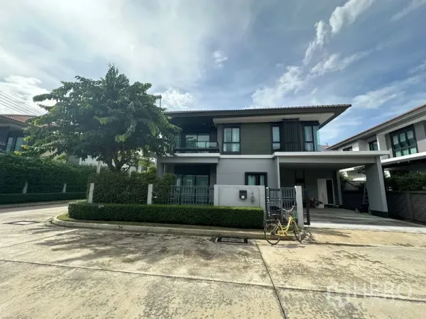 Detached House for rent in Lam Luk Ka, Pathum Thani - Two-storey detached house on a corner plot with hedge fence, balcony and driveway.