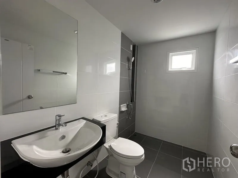 Detached House for sale in Lam Luk Ka, Pathum Thani - Bathroom with gray floor tiles, shower area and a small window.