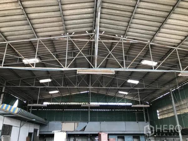 Warehouse for rent in Bang Phli, Samut Prakan - Close view of steel-truss roof with skylights and ventilation panels inside Bang Phli warehouse.
