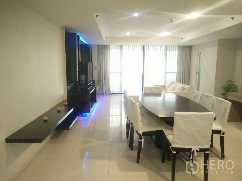 Condominium for rent or sale in Watthana, Bangkok - Bright dining and living space with large windows, sheer curtains and a sofa set.