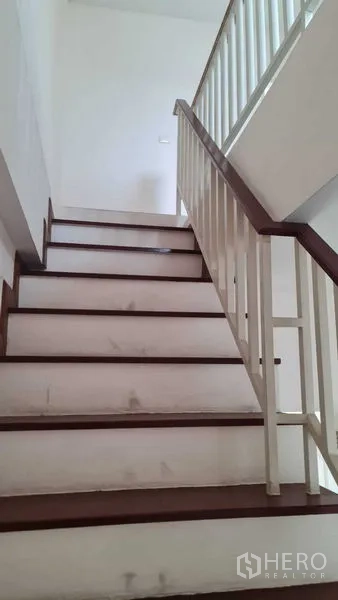 Townhouse for  in Lam Luk Ka, Pathum Thani - Wide interior staircase with wooden treads and white balustrade.