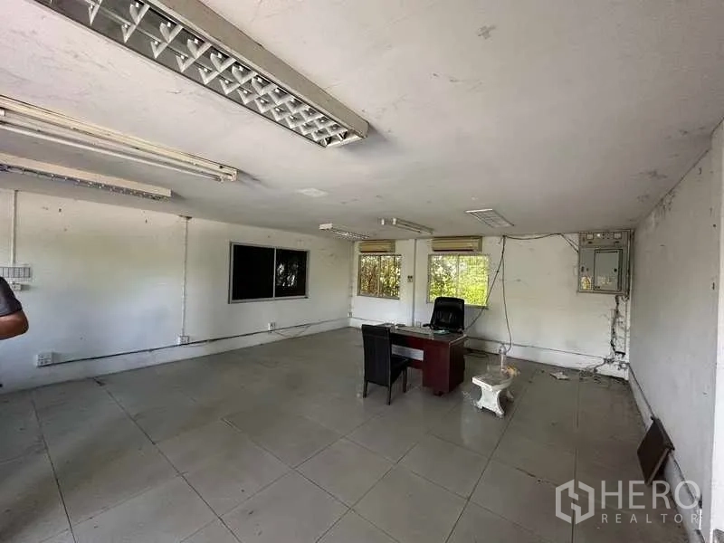 Warehouse for rent in Wang Noi, Phra Nakhon Si Ayutthaya - Large office room with windows and basic desk, tiled flooring and ceiling lights within the facility.
