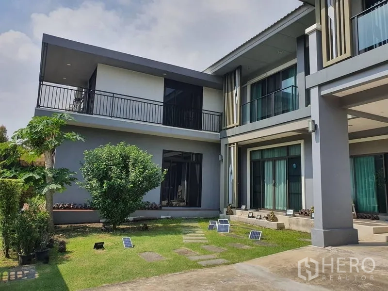 独立式住宅 出售在Suan Luang, Bangkok - 房屋两翼之间的私家庭院草地，配落地推拉门与环绕式阳台。