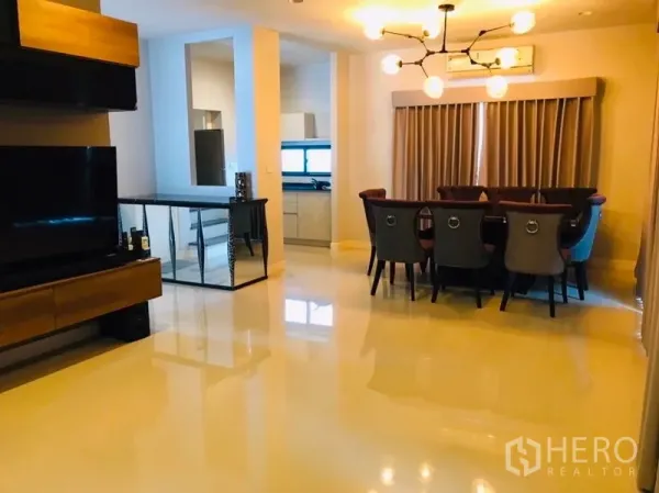 Detached House for rent or sale in Pathum Thani - Open-plan living and dining area with chandelier and view to a fitted kitchen.