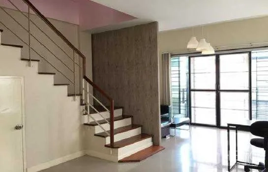 Home Office for rent in Lat Phrao, Bangkok - Living area with staircase, floor-to-ceiling doors and a compact counter.