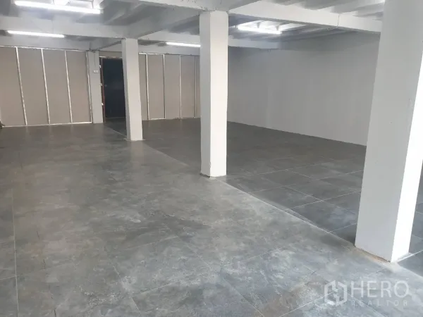Retail Space for rent in Khlong Toei, Bangkok - Open-plan retail interior with grey tile flooring, white support columns and bright strip lighting.