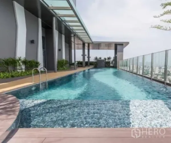 Condominium for rent in Khlong Toei, Bangkok - Rooftop swimming pool with glass balustrade and skyline view at a modern condo.