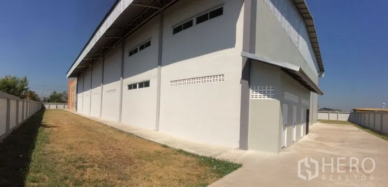 Factory for sale in Bang Sao Thong, Samut Prakan - Front façade of the glass-front office connected to the large warehouse.