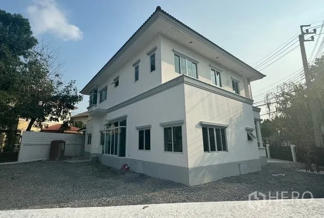 บ้าน ขายในPak Kret, Nonthaburi - พื้นที่หลังบ้านโรยกรวดและผนังบ้านที่มีหน้าต่างจำนวนมาก