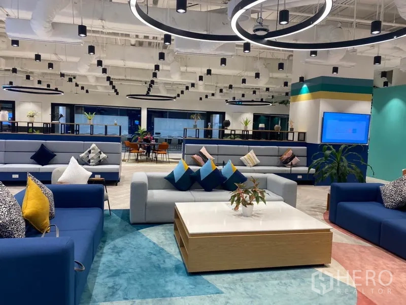 Office Space for rent in Pathum Wan, Bangkok - Modern lounge with sofas, coffee table and circular pendant lights in a shared area.