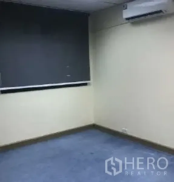 办公空间 出租在Bang Rak, Bangkok - 办公角落，蓝色地毯、壁挂空调和遮光窗帘。
