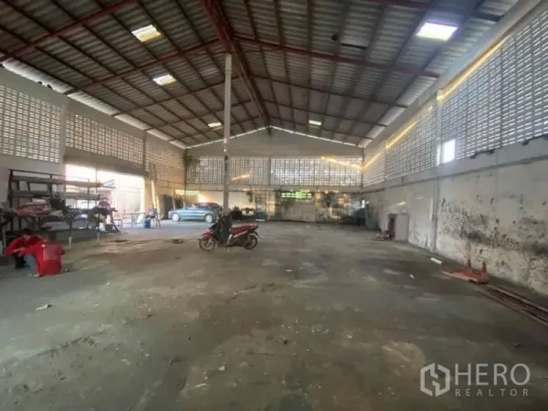 Factory for sale in Nong Chok, Bangkok - Spacious factory interior with high steel roof, ventilation block walls and open floor.