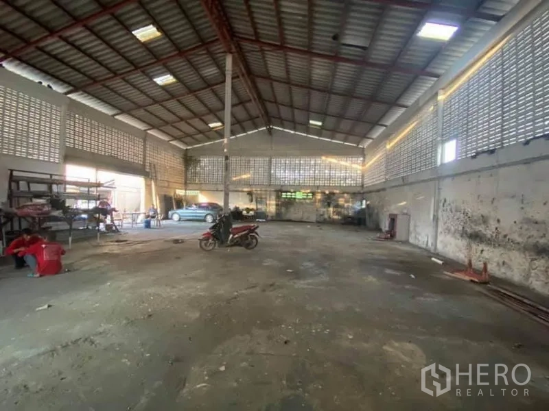 Factory for sale in Nong Chok, Bangkok - Spacious factory interior with high steel roof, ventilation block walls and open floor.