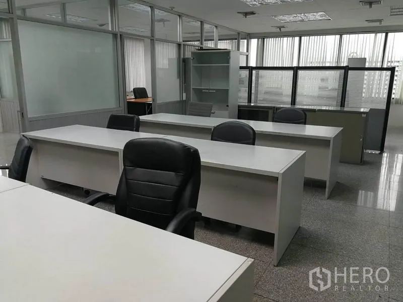 Office Space for rent in Bang Na, Bangkok - Rows of office desks and chairs in a glass-partitioned open-plan area.
