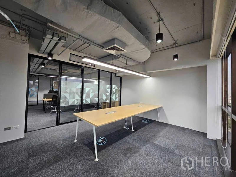 办公空间 出租在Ratchathewi, Bangkok - 转角办公室区域，长条工位、吊灯与大窗城市景观