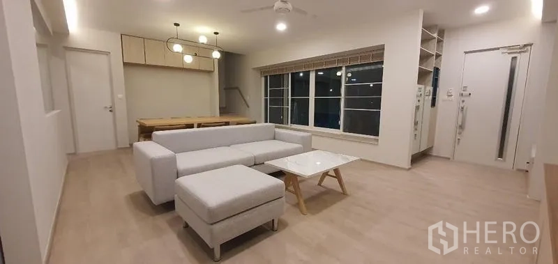 Detached House for rent - Living and dining space with L-shaped sofa and six-seat dining table.