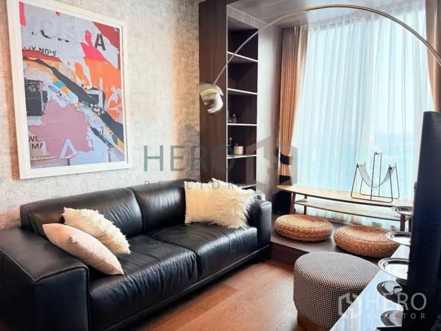 Condominium for rent - Ideo Q Sukhumvit 36 living room with black leather sofa, arc lamp, built-ins and a Zen balcony nook.