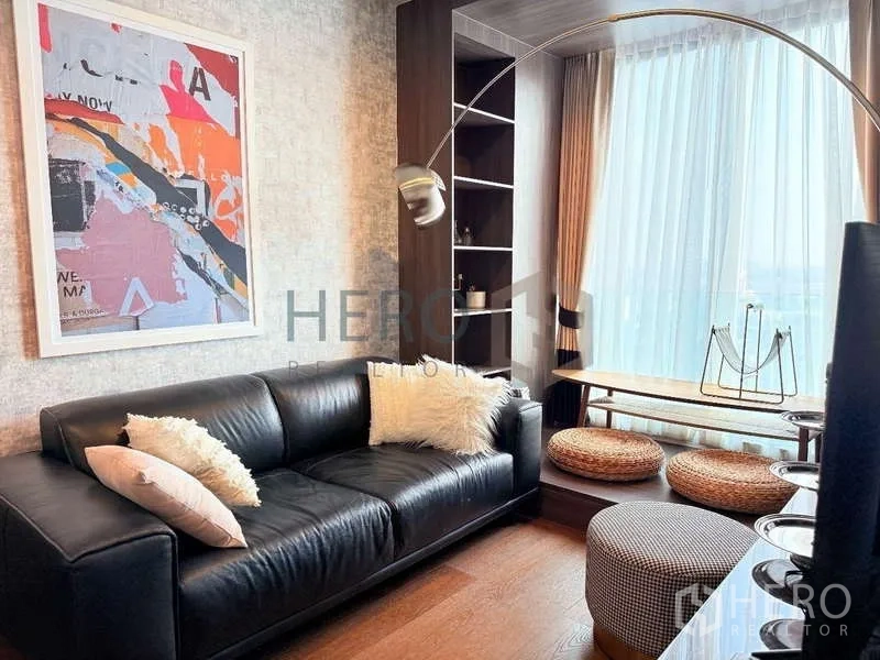 Condominium for rent - Ideo Q Sukhumvit 36 living room with black leather sofa, arc lamp, built-ins and a Zen balcony nook.