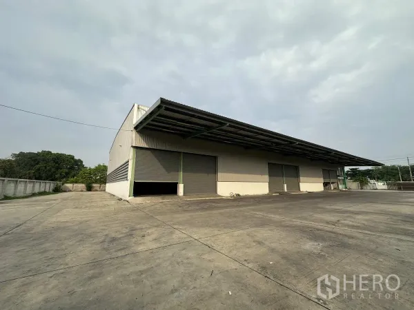 工厂 出租在Mueang Samut Prakan, Samut Prakan - 仓库侧面，带顶装卸平台、卷闸门与围墙场地。