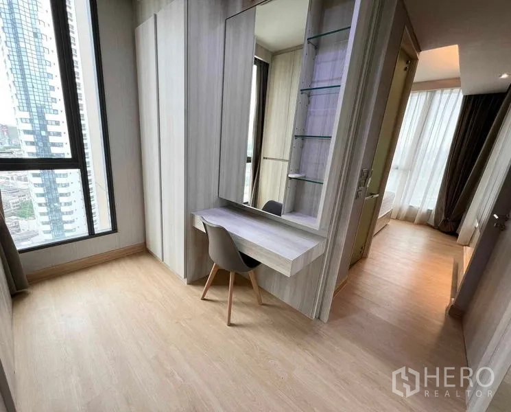 Condominium for rent or sale - Dressing area and corridor with floating desk, mirrored shelving, and doorway to the bedroom.