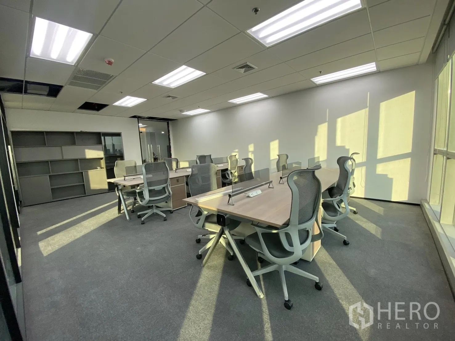 办公空间 for rent in Huai Khwang, Bangkok - 开放式工位区，成排桌椅与地毯地面，采光充足。