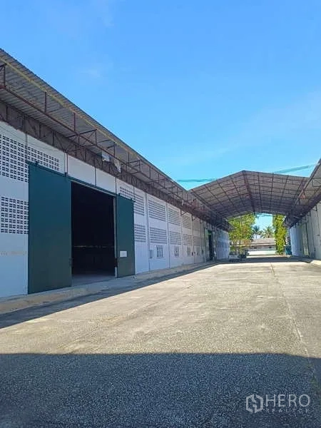 Warehouse for rent in Mueang Rayong, Rayong - Row of warehouse bays with canopy covering the wide access road.