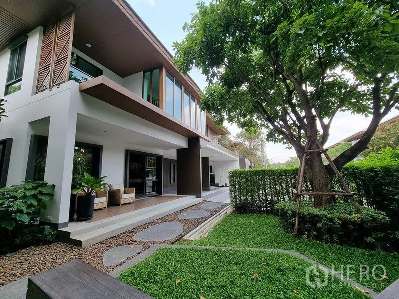 Detached House for rent in Prawet, Bangkok - Landscaped garden beside a modern two‑storey house with covered terrace.