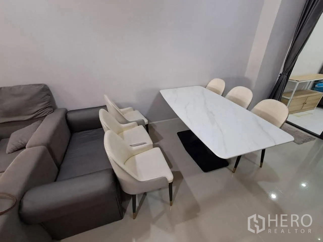 Townhouse for rent in Bang Kapi, Bangkok - Dining area with a white marble-top table and upholstered chairs.
