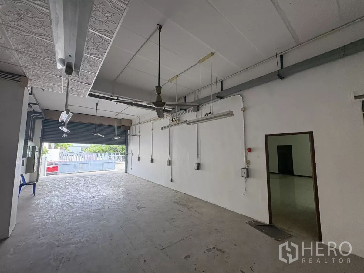 Warehouse for rent in Bang Phli, Samut Prakan - Open loading door leading to front yard, adjacent to side room and control panels.