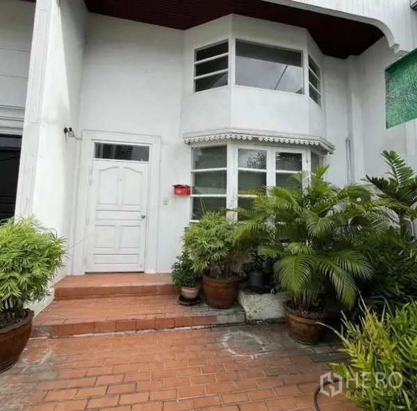 Home Office for rent in Bang Rak, Bangkok - Front entry with bay window and potted greenery on a terracotta-tile patio.