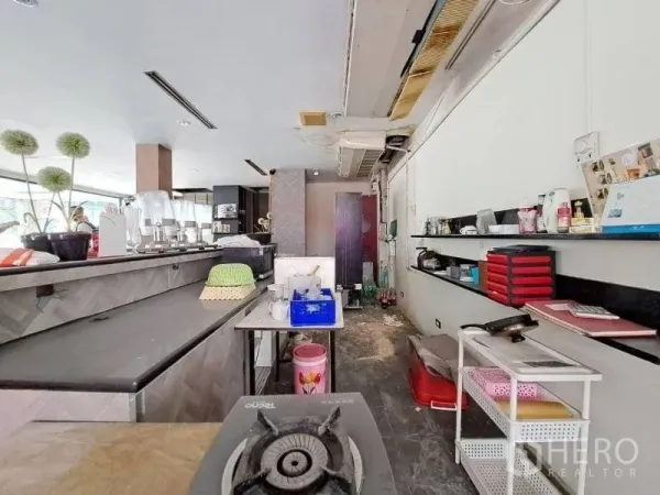Retail Space for rent - Retail unit interior with long service counter, open shelving and bright window light.