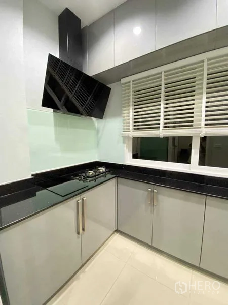 Detached House for rent in Bang Khen, Bangkok - Modern kitchen with gas hob, angled hood, upper cabinets and window blinds.