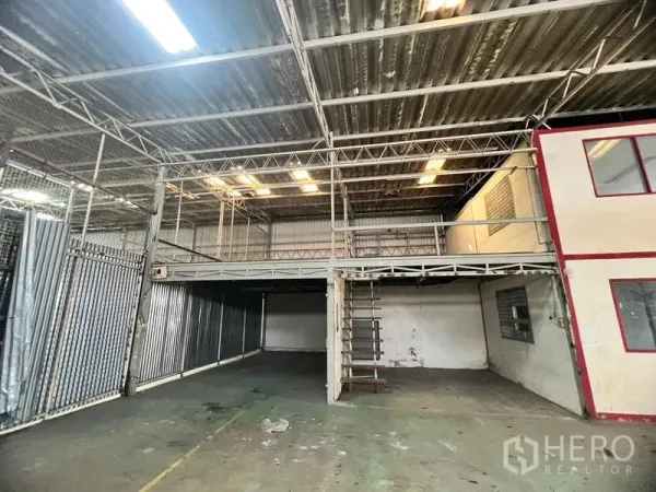 Warehouse for rent in Suan Luang, Bangkok - Mezzanine storage platform with metal stairs and corrugated metal partitions.