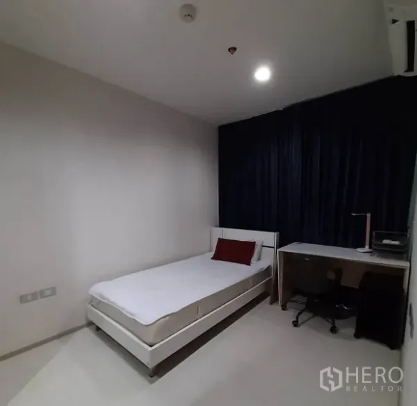 Condominium for rent or sale in Khlong Toei, Bangkok - Second bedroom with a single bed, study desk, office chair and blackout drapes.