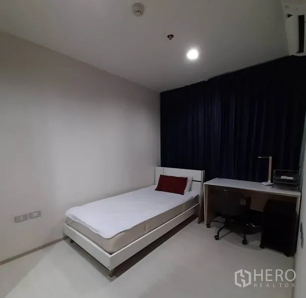 Condominium for rent or sale in Khlong Toei, Bangkok - Second bedroom with a single bed, study desk, office chair and blackout drapes.