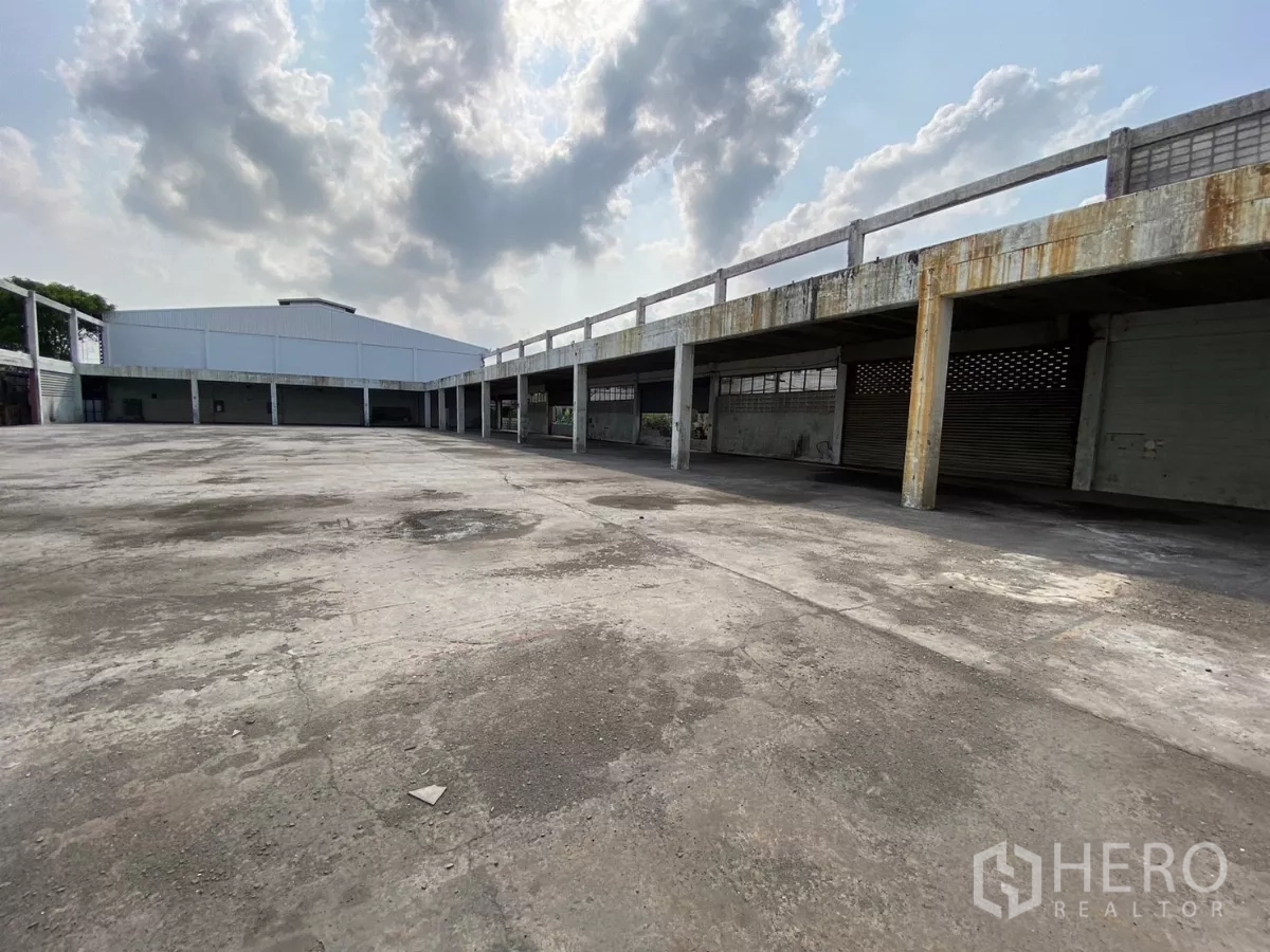 工厂 出售在Bang Phli, Samut Prakan - 斜角视图：开阔院场、长廊式雨棚与周边装卸位。
